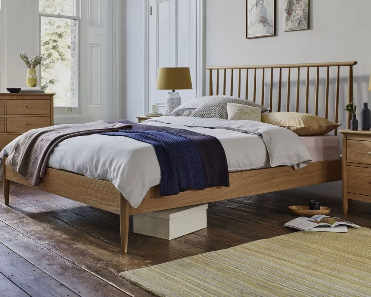Ercol Teramo Bed Frame in bright bedroom with wooden floors and mustard accessories