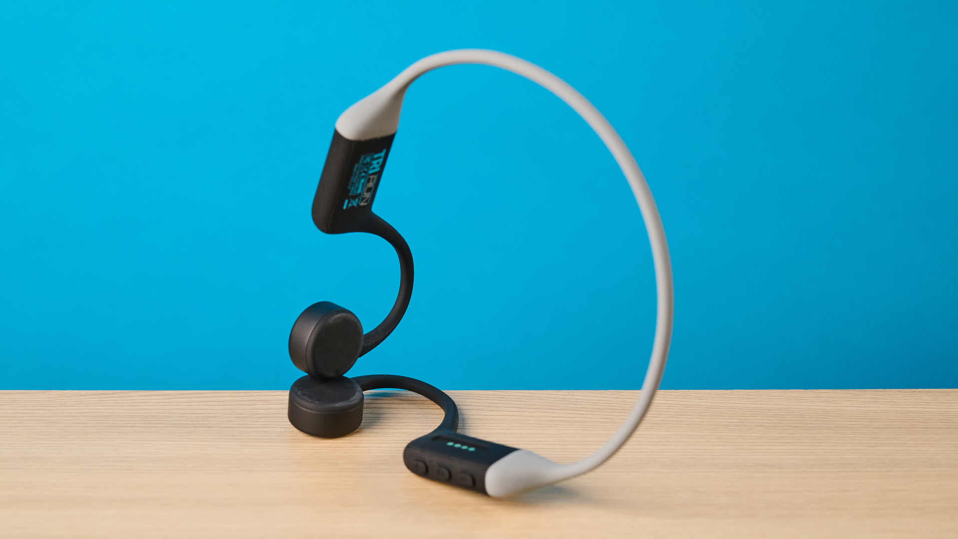 the h2o audio tri run bone conduction headphones photographed against a tom's guide blue background