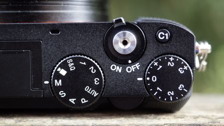 Sony RX1R III on a wooden surface in a woodland environment