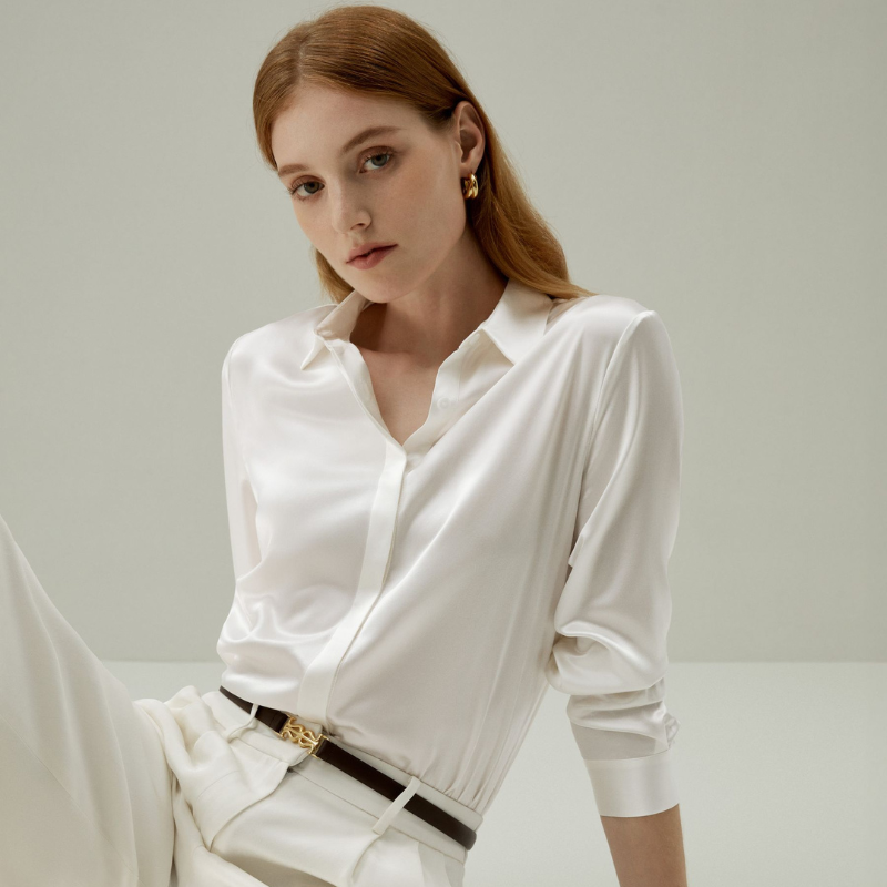 A model wearing a white silk shirt with white trousers