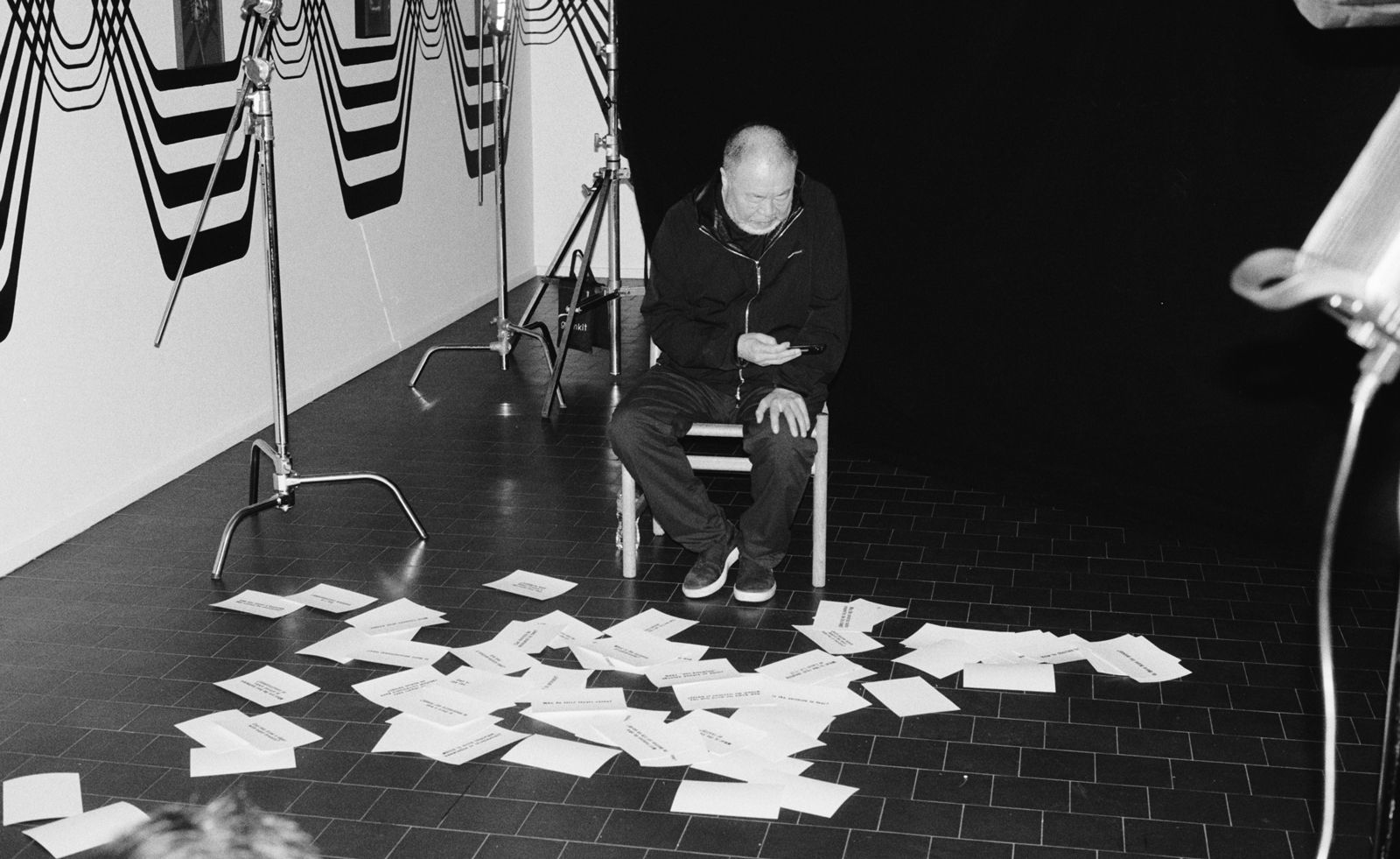 ai weiwei seated with paper on the floor