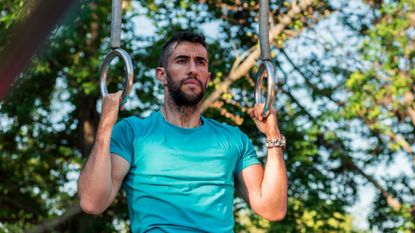 Man using gym rings to work out