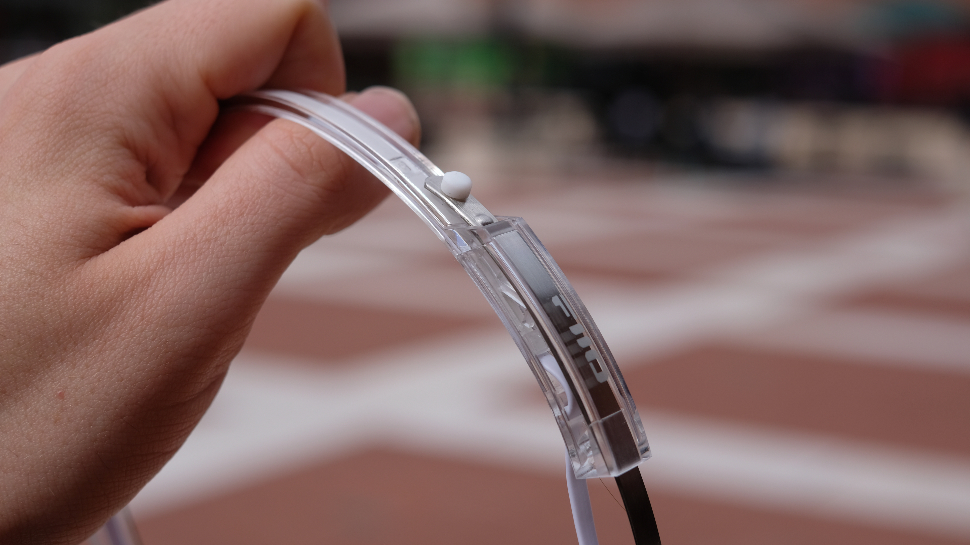 A photograph of the FiiO EH11 over-ear headphones with a transparent frame and orange foam earpads.