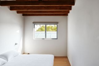Emeco House minimalist bedroom with a bed with white linen