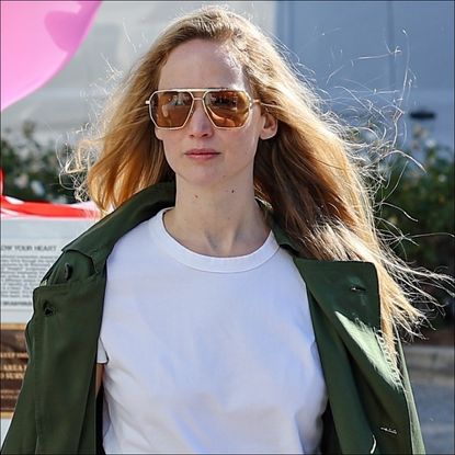 Jennifer Lawrence wears a white t shirt, trench coat, and denim skirt while out in los angeles