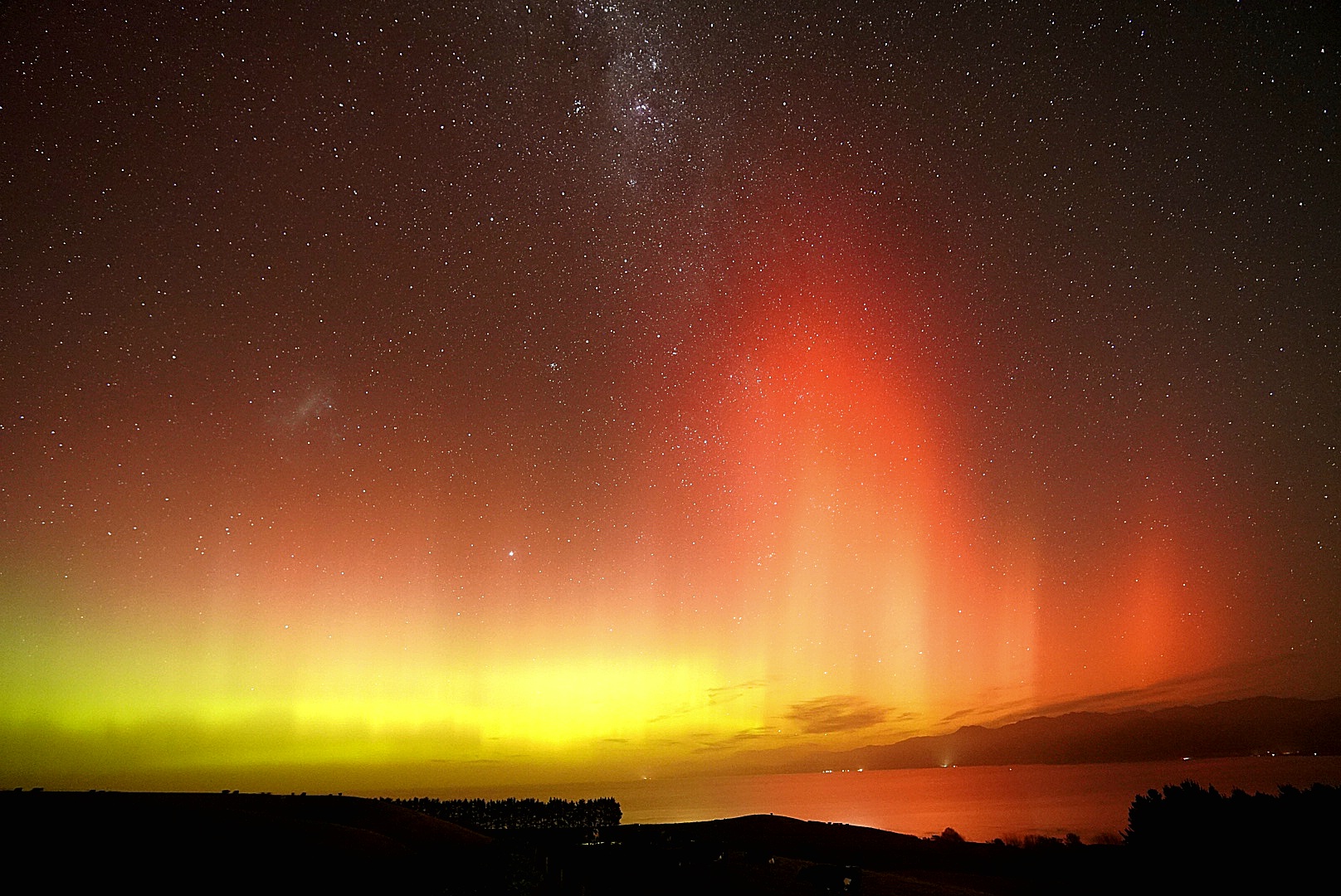 auroras colored yellow and red above kaikoura New Zealand.