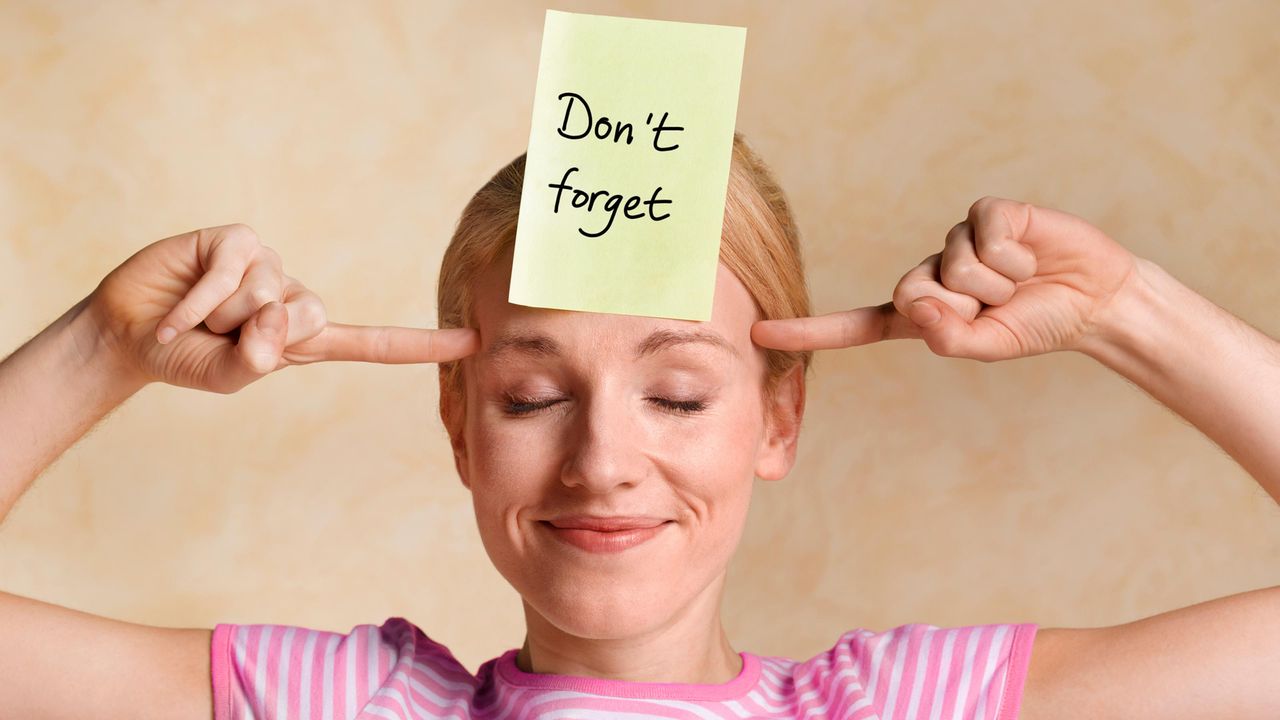 A woman with a Post-It Note on her forehead that reads, &amp;quot;Don&amp;#039;t Forget.&amp;quot;