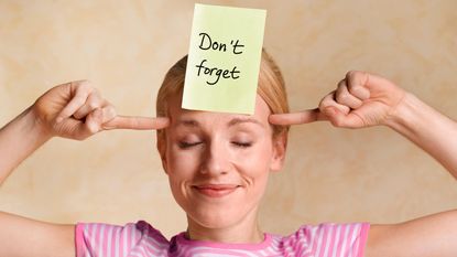 A woman with a Post-It Note on her forehead that reads, "Don't Forget."