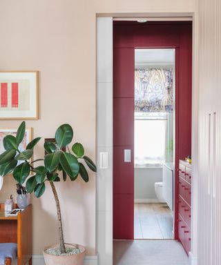 Dressing room and walk in wardrobe leading to bathroom with red furniture