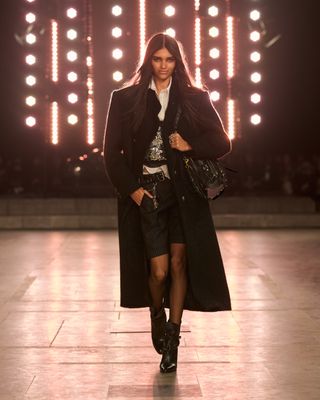 Isabel Marant model wears black coat and black shorts