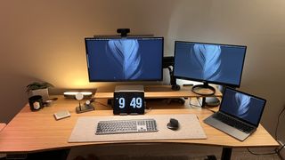 FlexiSpot E8 in a home office with multiple monitors and devices