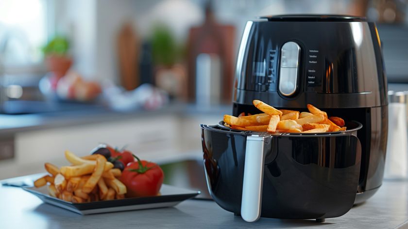  A sleek black air fryer sits on a modern kitchen countertop, perfectly crisping golden fries