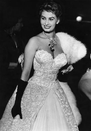 Sophia Loren mengenakan gaun strapless dengan sarung tangan hitam sepanjang siku di festival film Cannes