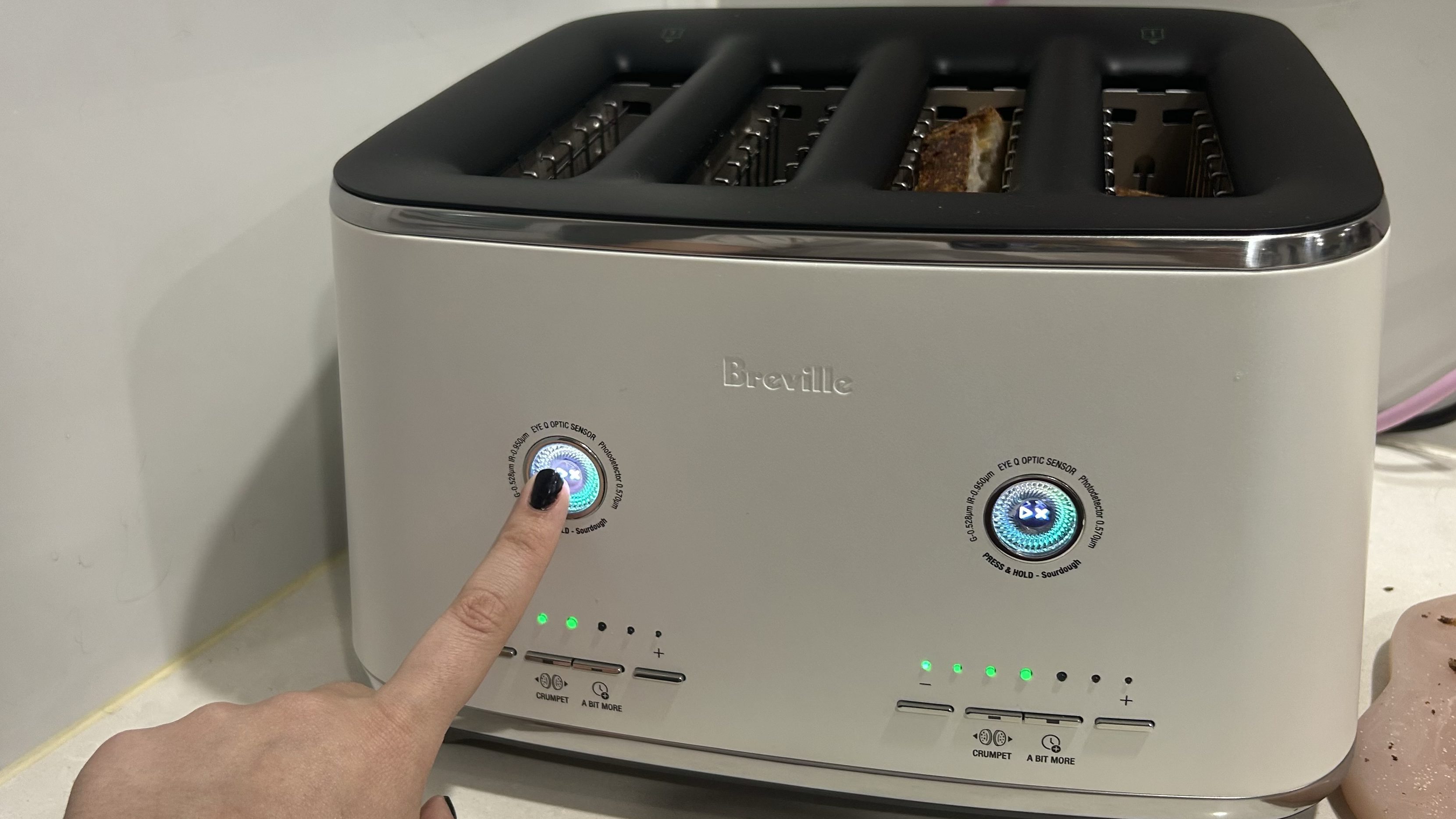 Finger activating Sourdough mode on Breville Eye Q toaster