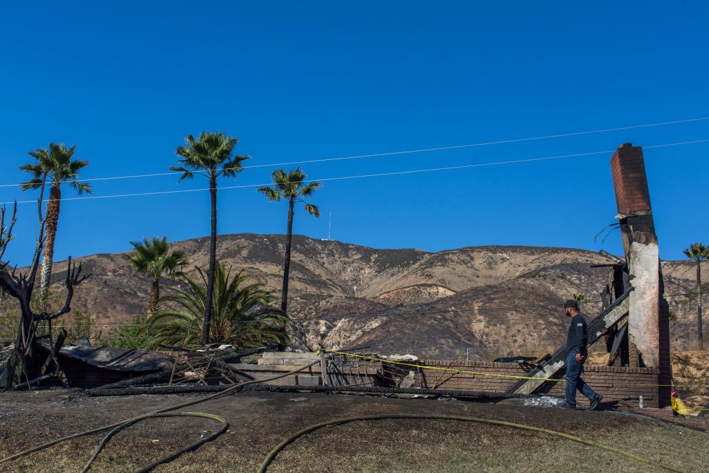 A man looks at what is left of his home that burned down.