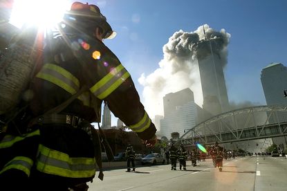 Firefighters race toward the burning twin towers.