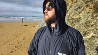 Finisterre Tego changing robe being worn on a beach