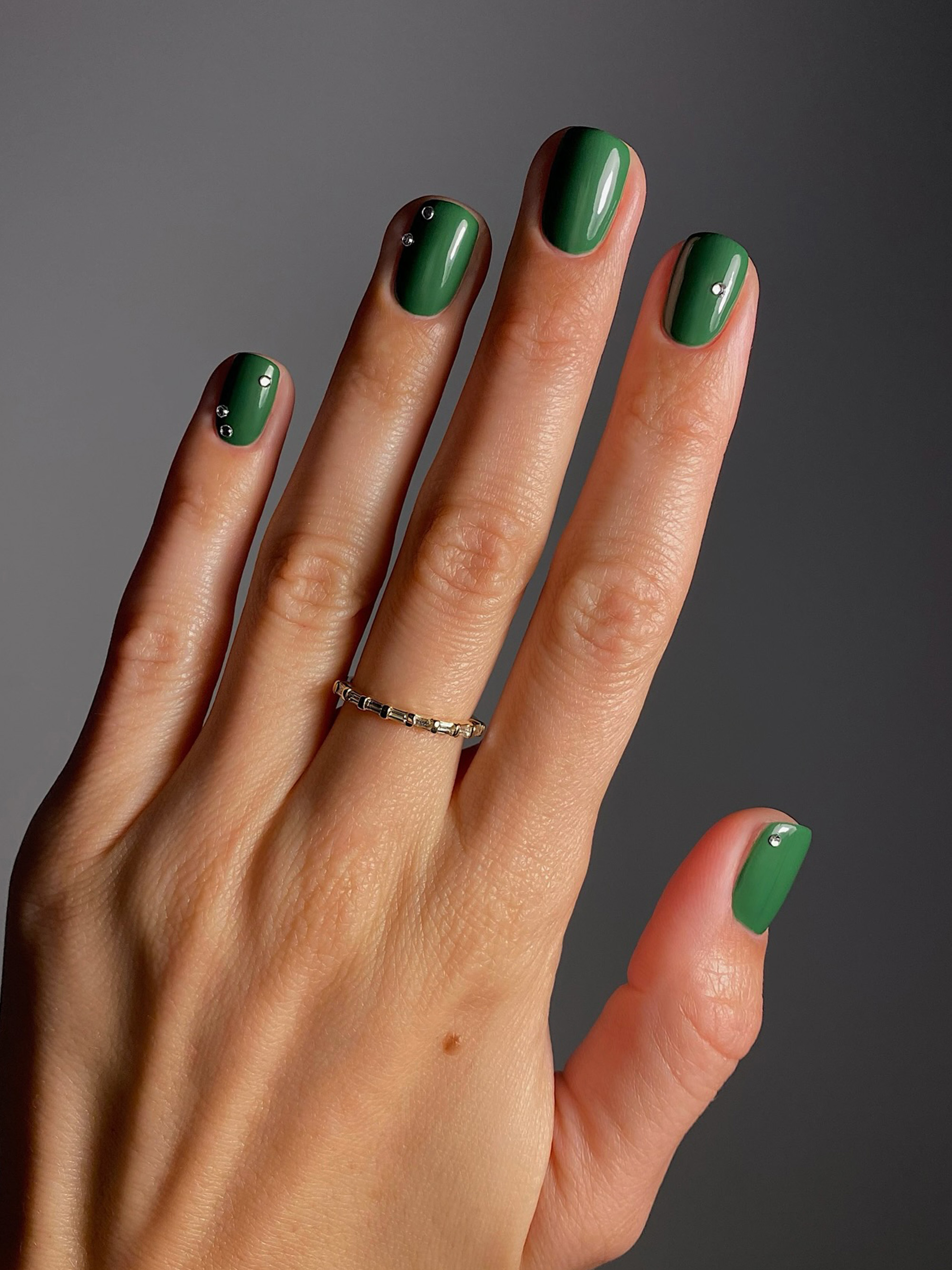 A green manicure with a subtle chrome design by Mateja Novakovic