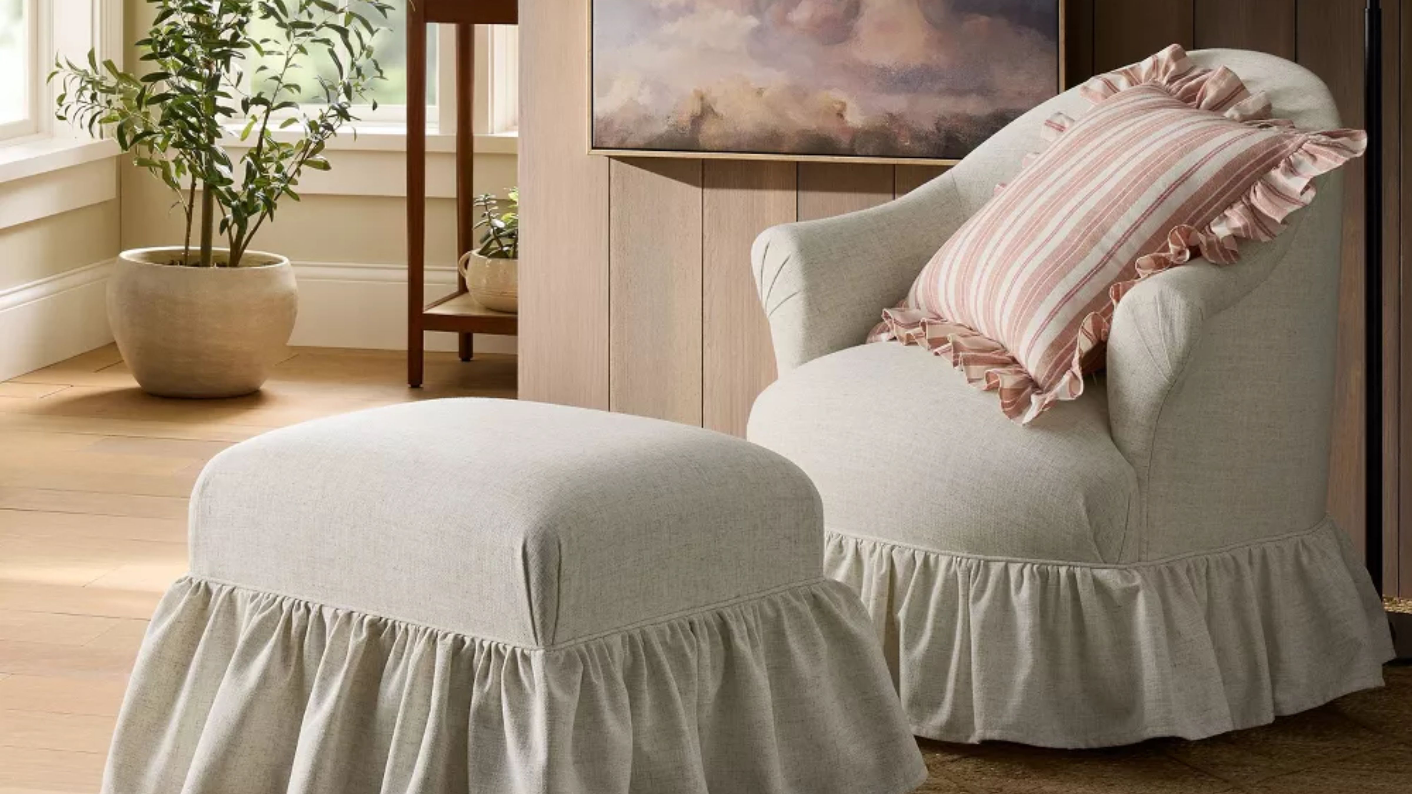 Shea McGee-designed ruffle swivel chair and matching ottoman pictured in a wood-paneled living room