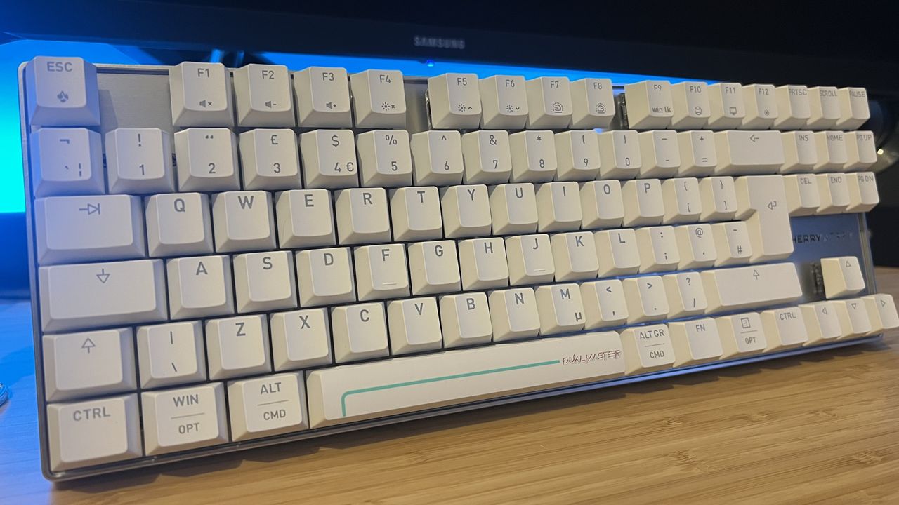 Cherry XTRFY MX 8.2 Pro TMR Wireless gaming keyboard standing upright on a wooden desk with blue backlighting