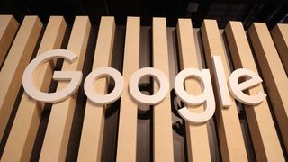 A telephoto shot of the Google logo, made of wood on a wall of wooden slats