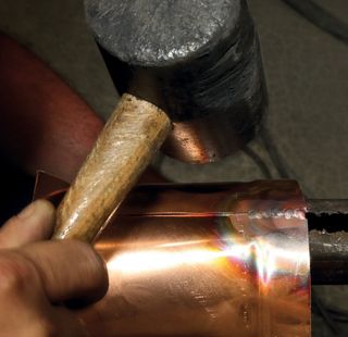 Hammer hitting copper material into shape