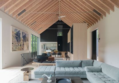 A living room with wooden rafters and neutral color scheme