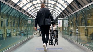 a photo of a man carrying the Brompton Electric P Line bike
