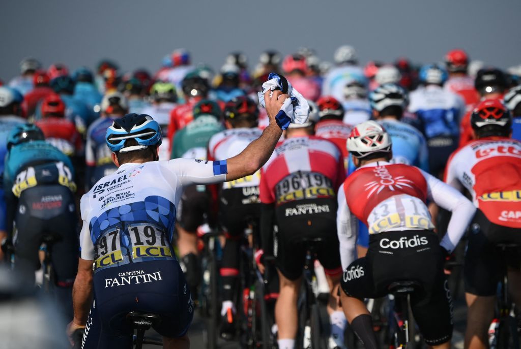 IsraelPremier Techs Belgian rider Tom Van Asbroeck L holds his jersey in the air as he waits for the arrival of his teams car during the 1st stage of the 80th edition of the Paris Nice cycling race 160 km between ManteslaVille and ManteslaVille on March 6 2022 Photo by FRANCK FIFE AFP Photo by FRANCK FIFEAFP via Getty Images