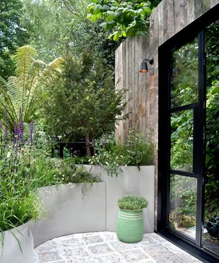 small courtyard garden with raised beds and plant pot