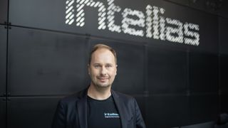 The Intellias co-founder Vitaly Sedler standing in front of the company logo