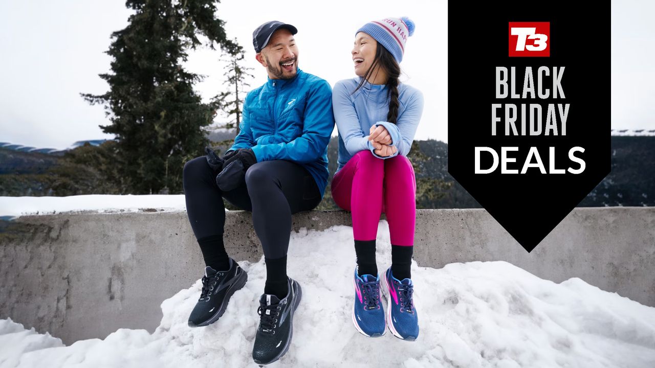 Two happy people sitting on concrete walls wearing Brooks running shoes