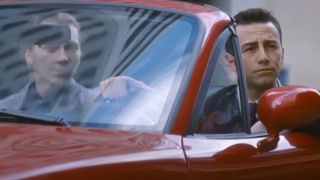 Paul Dano and Joseph Gordon Levitt cruising by in a red car in Looper.