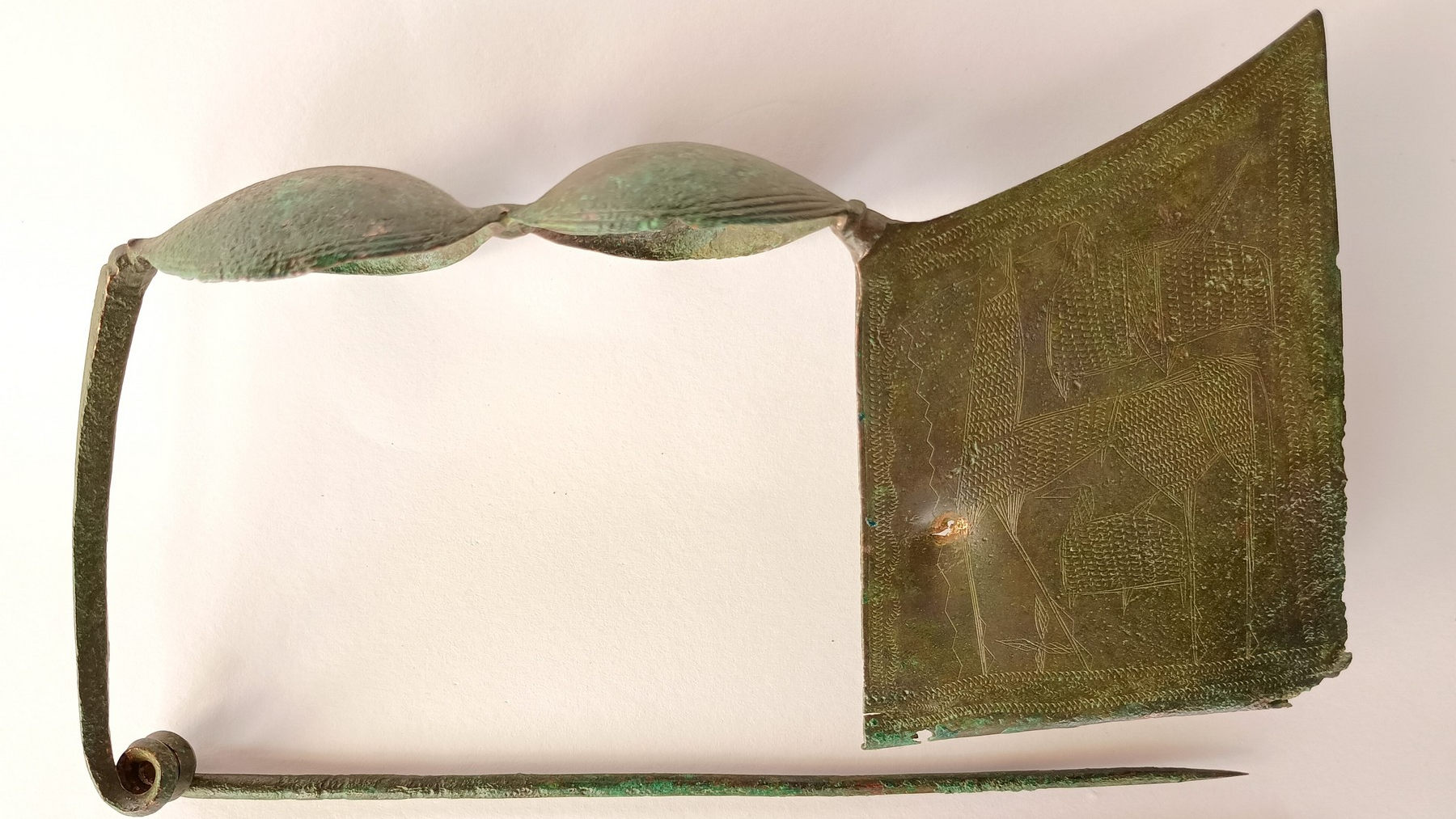 a rectangular bronze pin with geometric designs