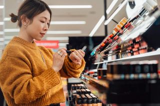 A woman is shopping for cosmetics in a department store.