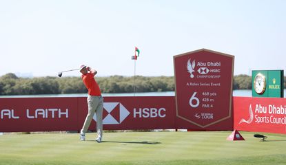 Meronk hits a tee shot in front of an HSBC Abu Dhabi Championship board