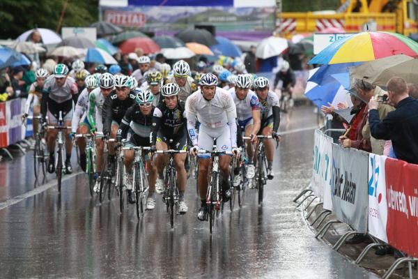 The peloton finishes in the rain at La Gileppe.