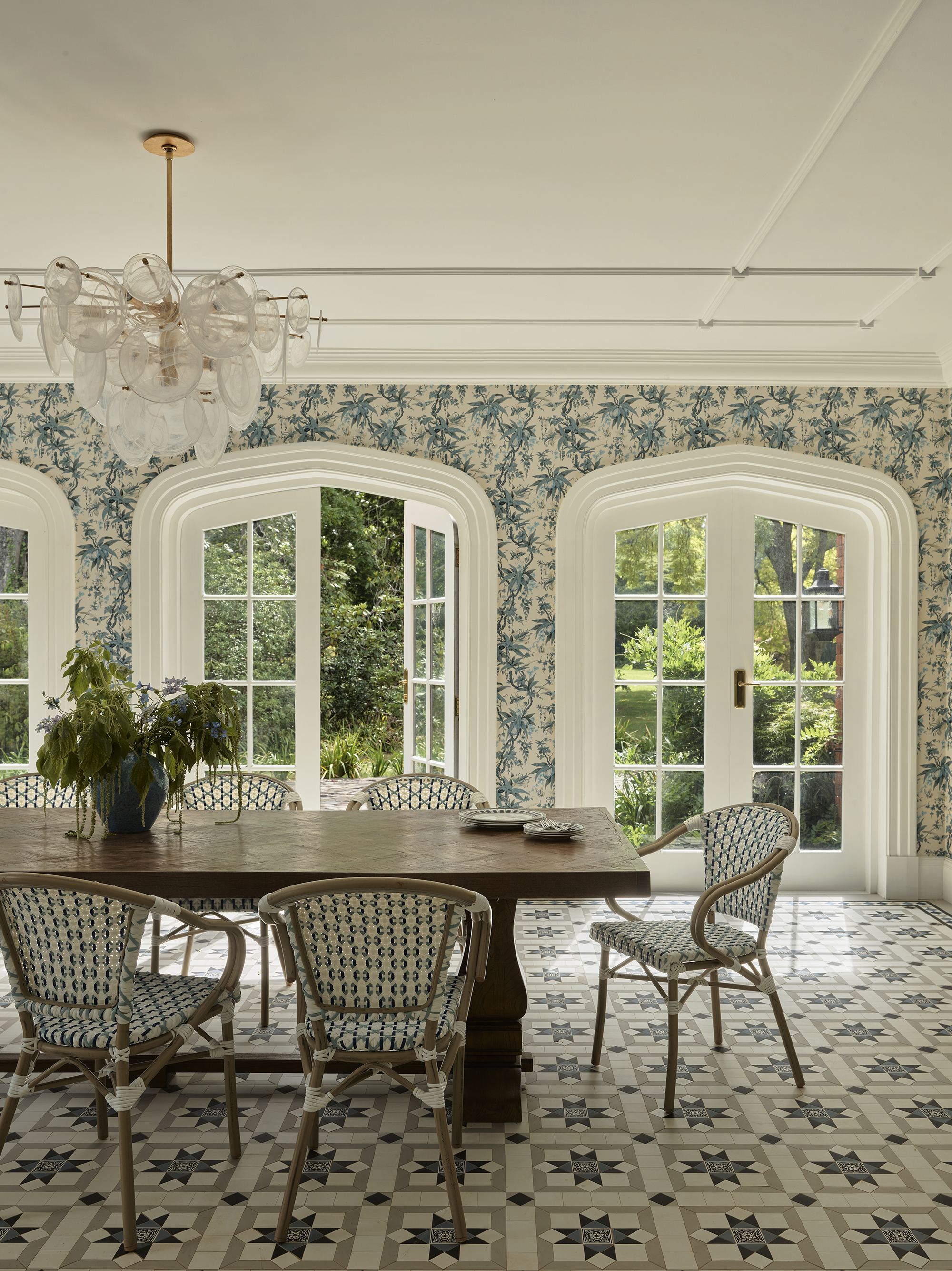 a botanical style dining room with floral wallpaper and tessellated tiles