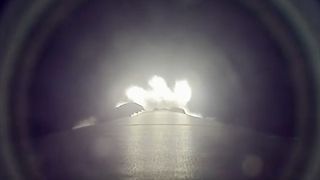 a downward-facing camera mounted on a rocket captures the booster's thrust as it climbs to space