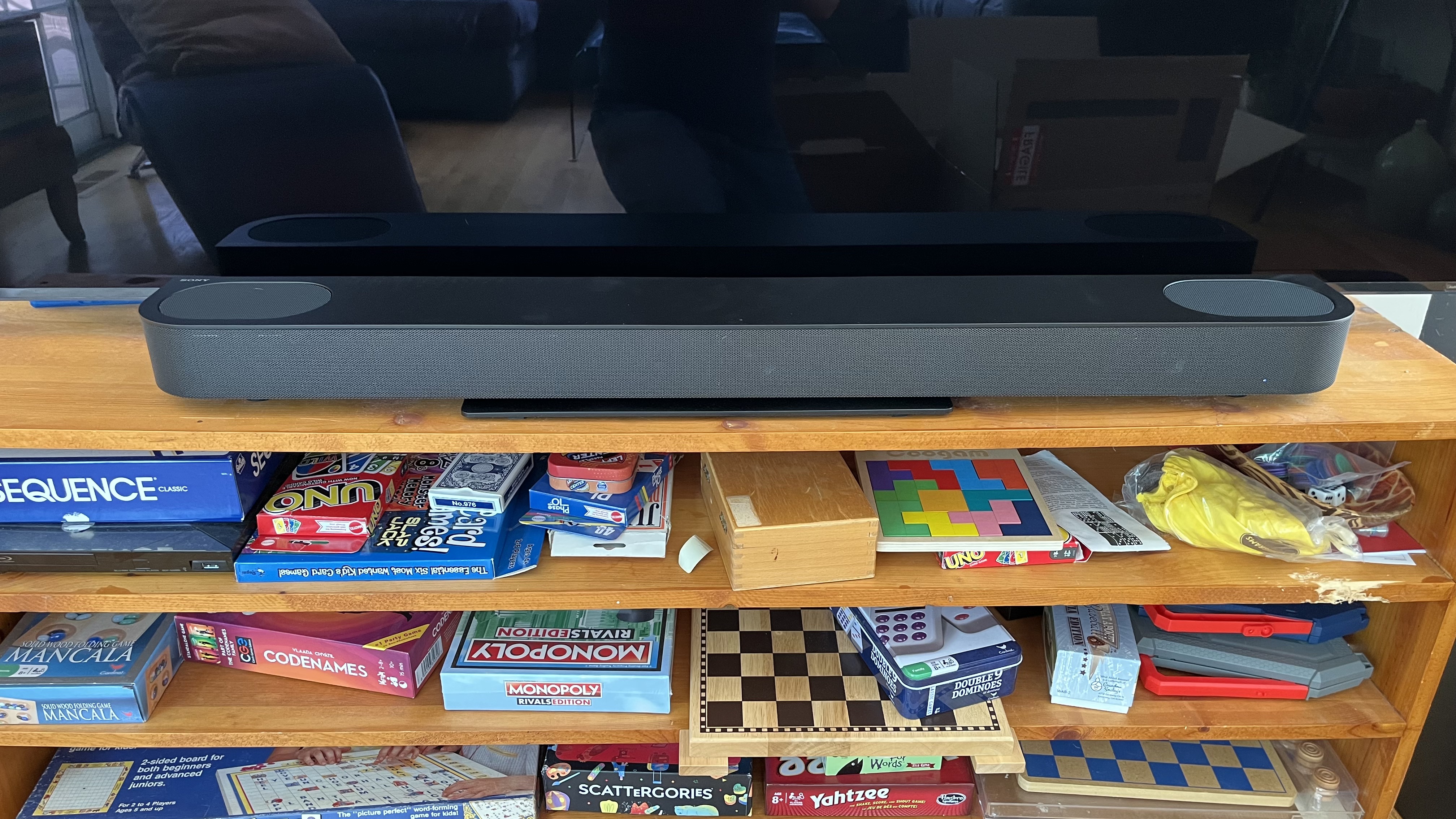 Sony Bravia theater bar 6 on tv stand with games beneath