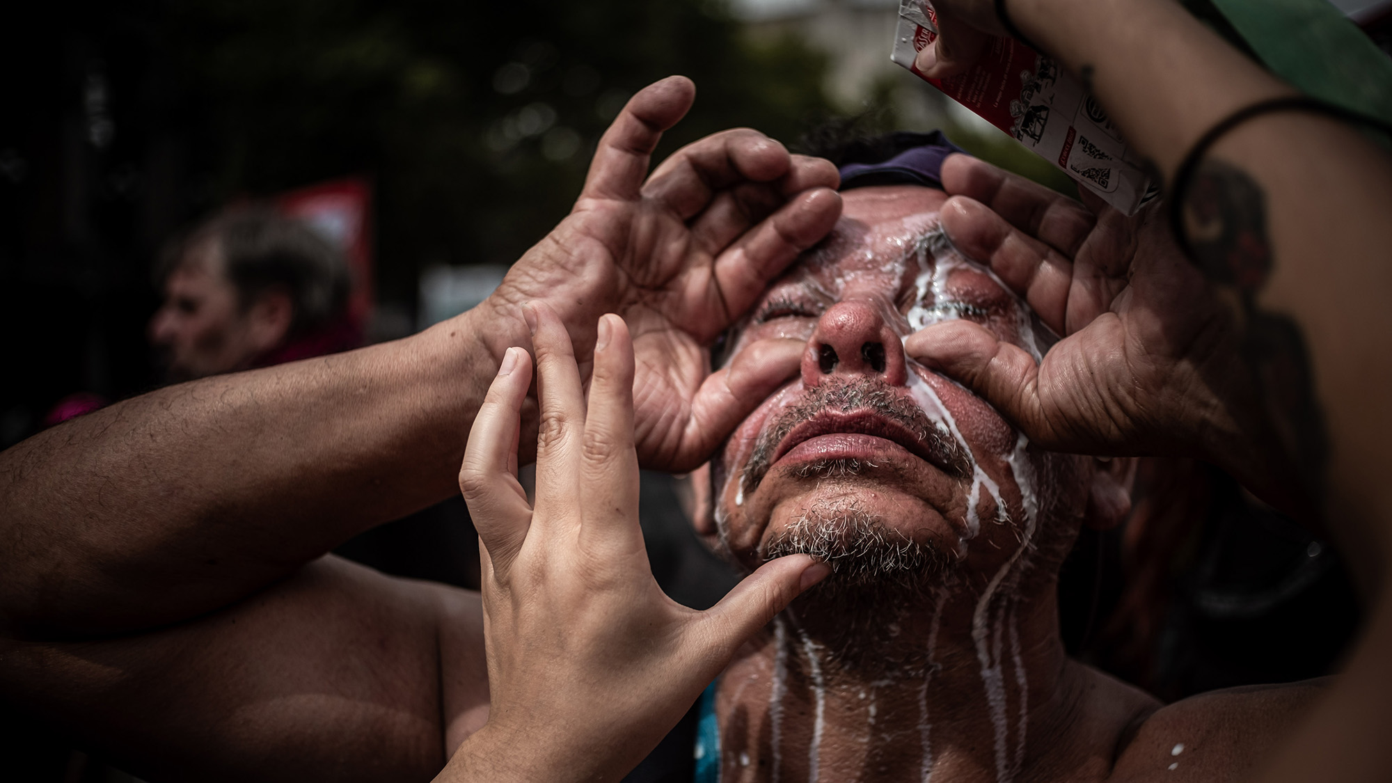 A protester attempts to clean tear gas out of his eyes following a security forces attack, Caba, Buenos Aires