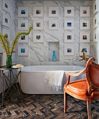 bathroom with freestanding bath, marble walls and photo gallery wall