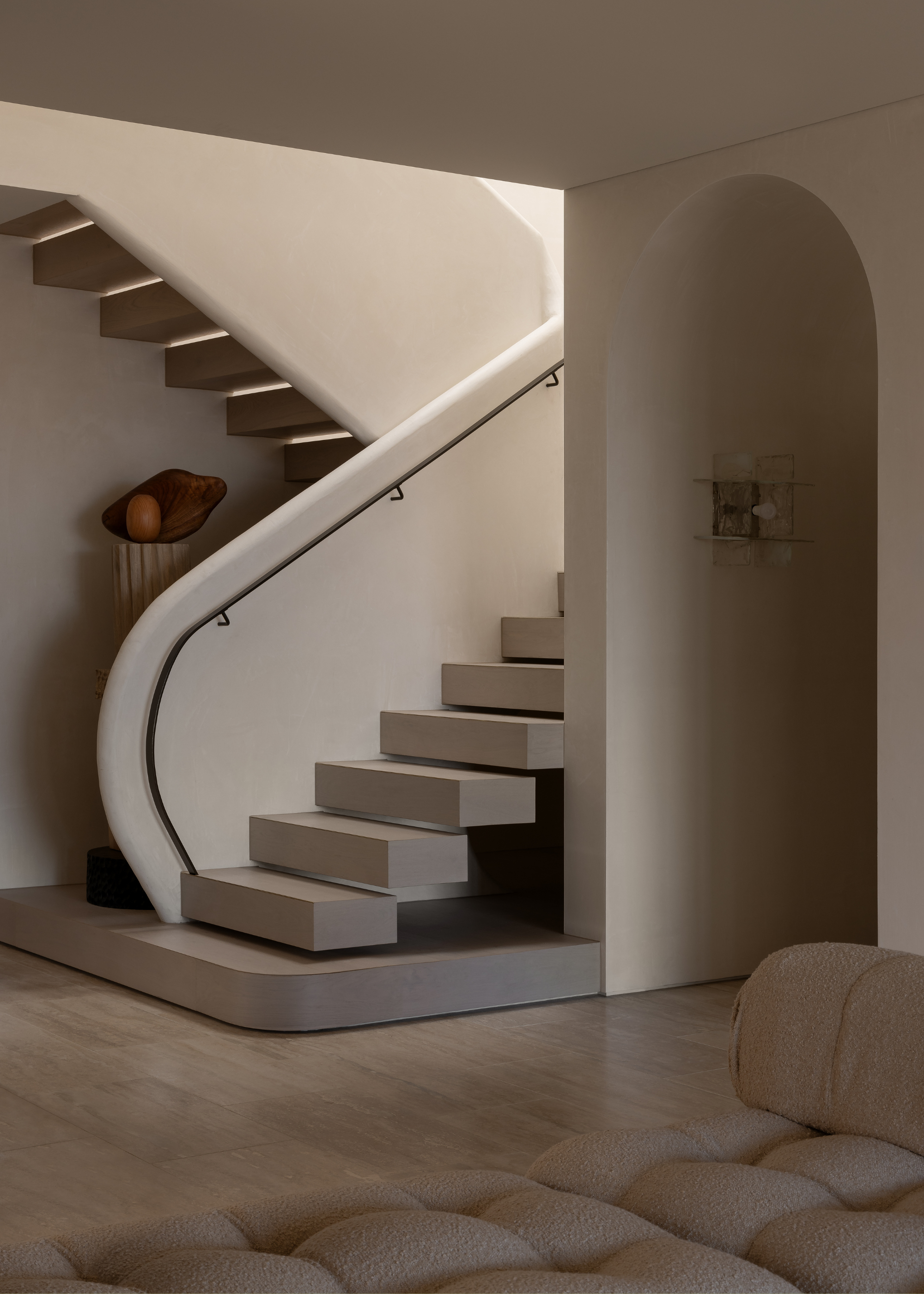 A sleek staircase with a soft, curved railing
