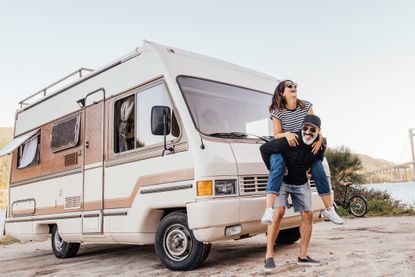 Happy couple outside a camper