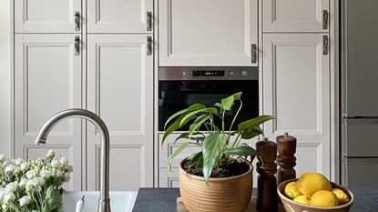 IKEA kitchen hack with white cabinets and flowers in sink