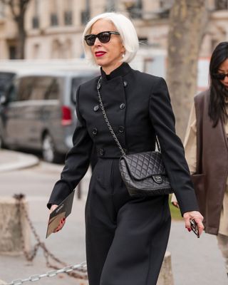 a woman walking with a grey bob hairstyle