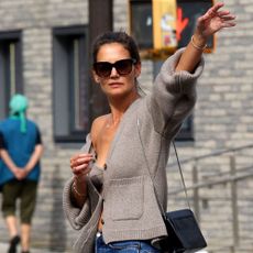 Katie Holmes flags down a taxi in New York wearing a Khaite cashmere cardigan and bra.