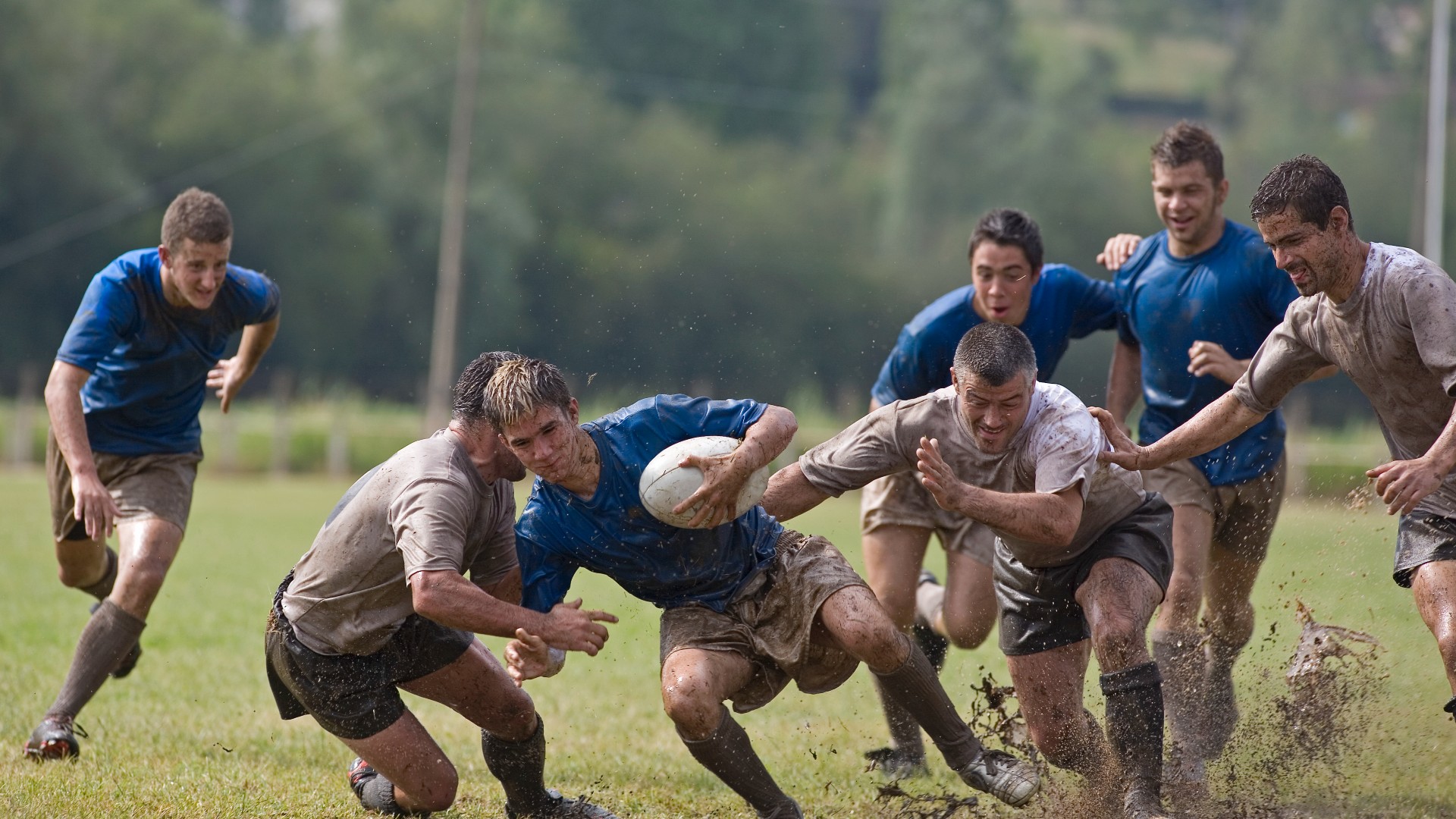image of men playing rugby tackling eachother on a field