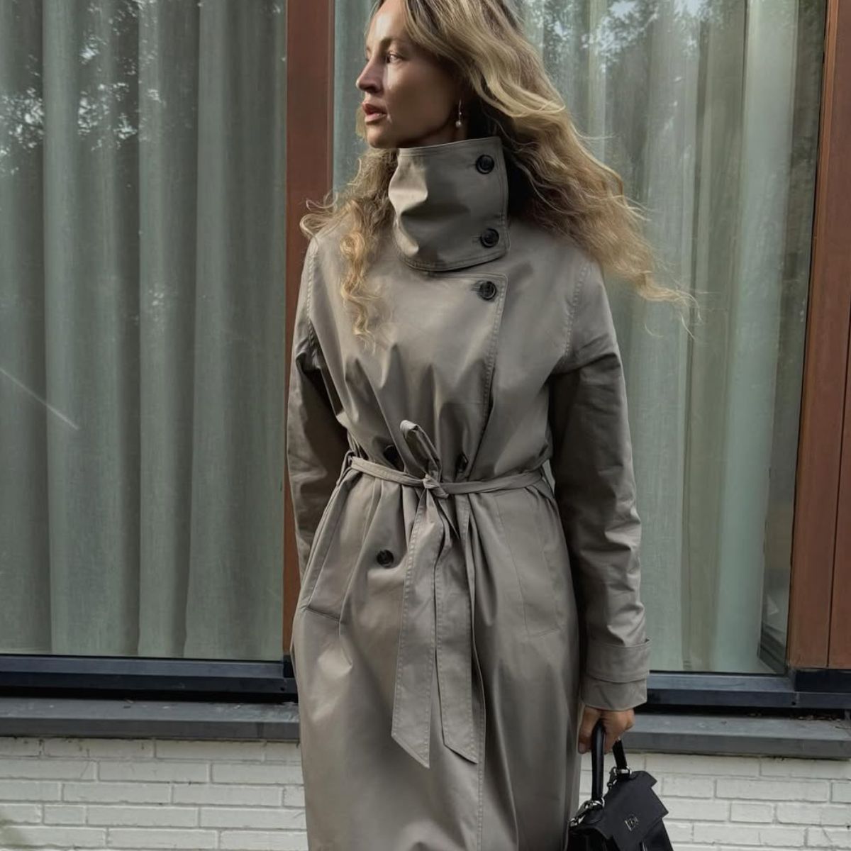 Blonde influencer wearing funnel-neck coat.