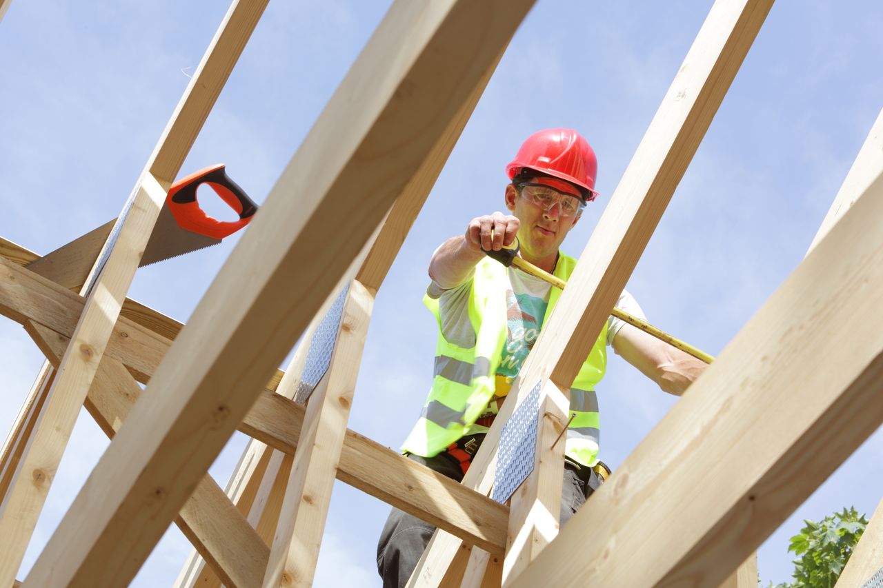 Builder working on roof of house